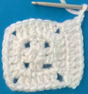 Crochet solid granny square row three first side